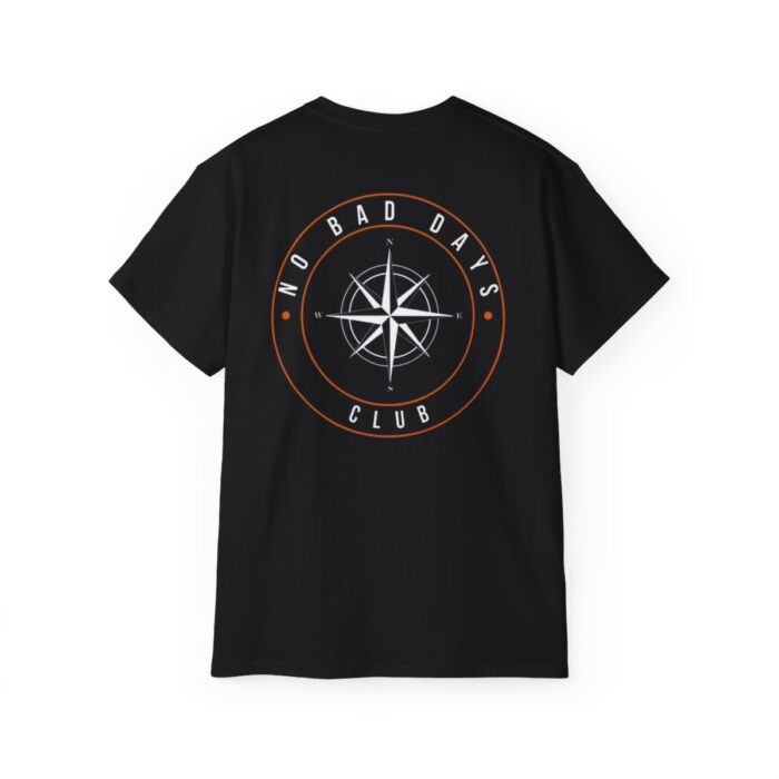 Black T-shirt featuring 'No Bad Days Club' logo, with a vibrant graphic of a beach scene including surfboards, the sea, and a bright sun, displayed on a plain background